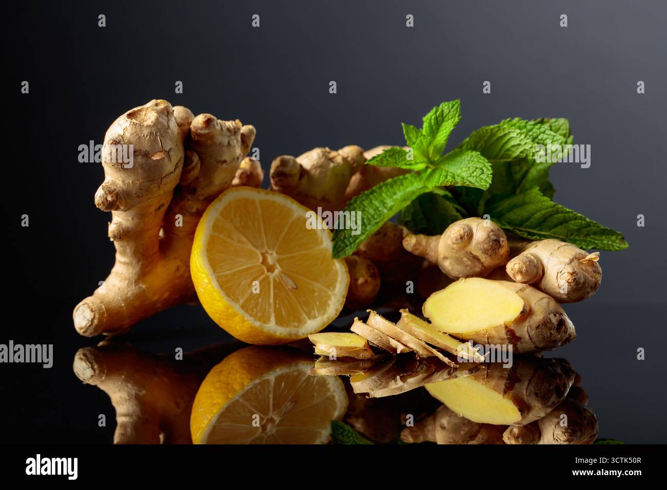 Gingembre au citron et à la menthe sur un fond réfléchissant noir. Banque D'Images