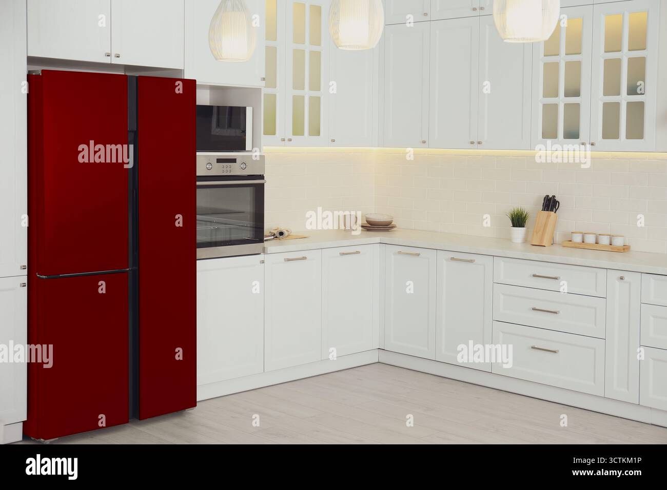 Réfrigérateur rouge et meubles dans la cuisine spacieuse Banque D'Images