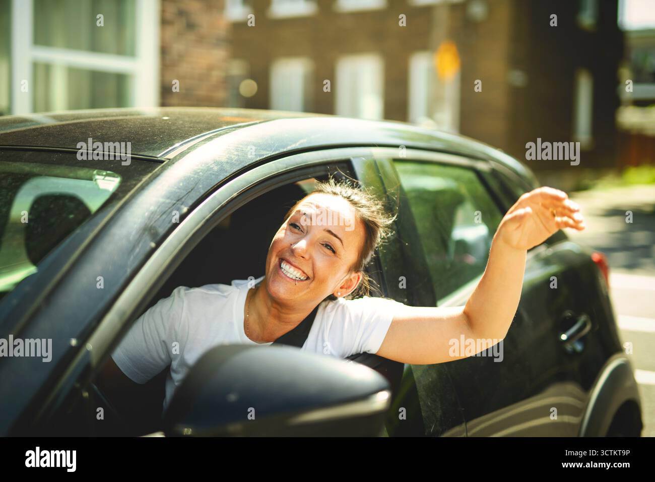 Une femme à la fenêtre de la voiture conduit une nouvelle voiture Banque D'Images