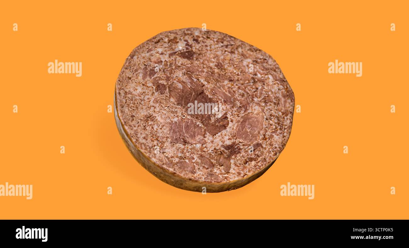 Tranche de viande transformée sur fond orange. Gros plan d'une tranche ronde de pain de viande isolé transformé ou de produit de viande en conserve. Utiliser pour les noix alimentaires Banque D'Images