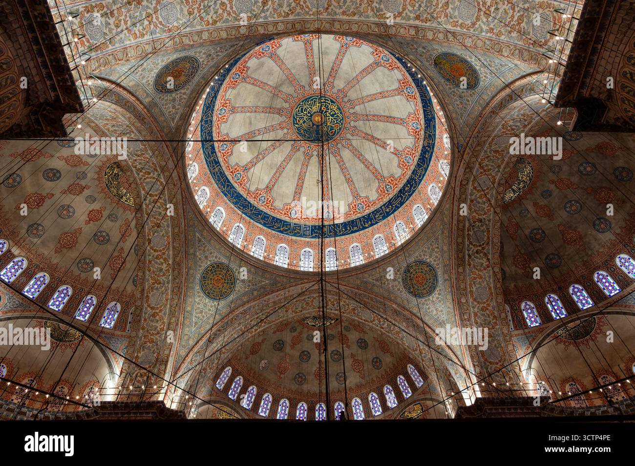 Vue intérieure vers le haut du plafond orné et des dômes de la Mosquée bleue à Istanbul, en Turquie, présentant des motifs islamiques complexes et des vitraux Banque D'Images