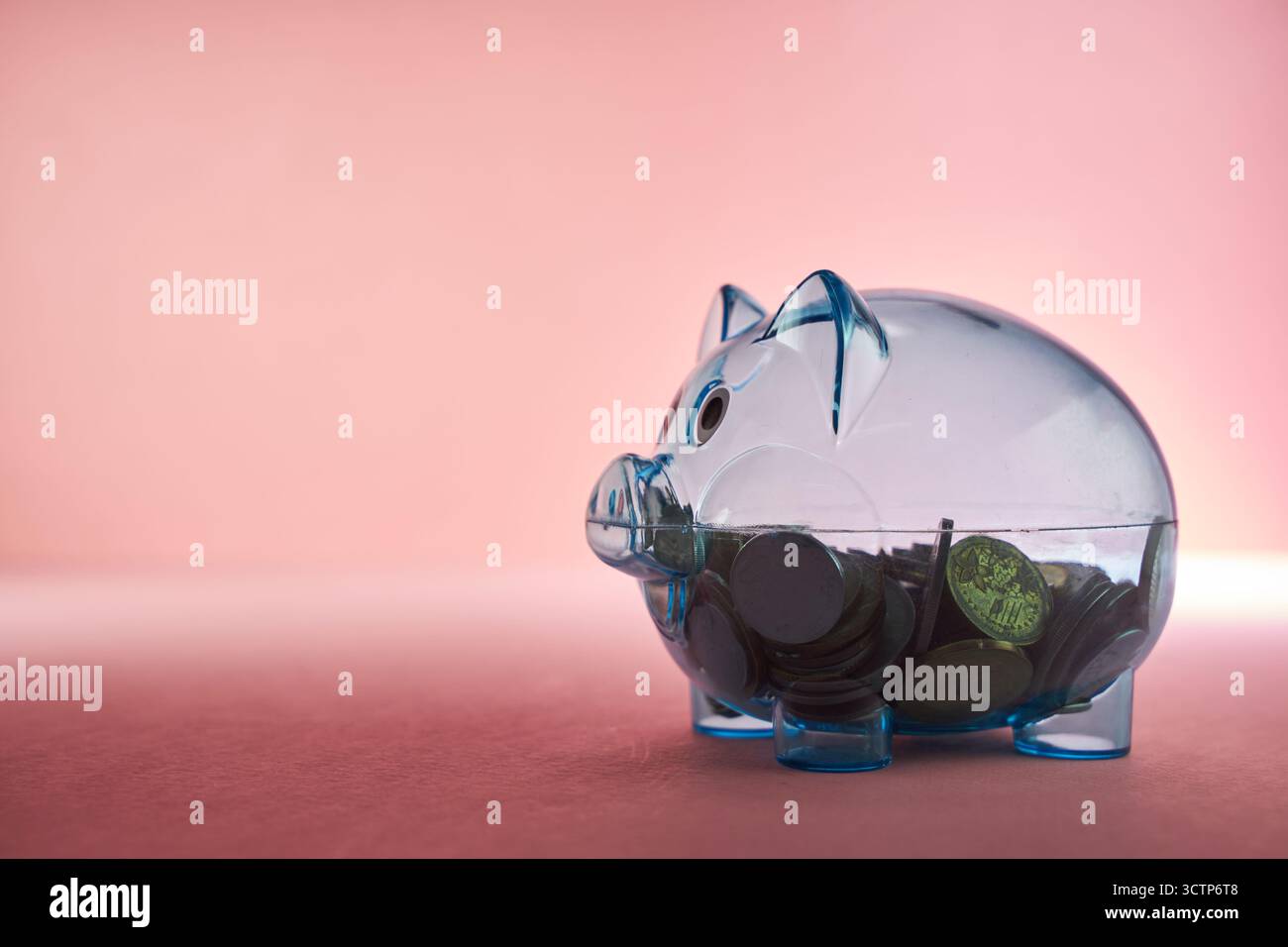 transparent see through tirelire remplie de pièces de monnaie. Banque D'Images