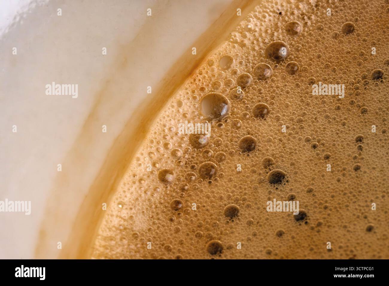 Gros plan de mousse de café sur la surface d'une boisson chaude. De minuscules bulles et une texture crémeuse soulignent la fraîcheur, l'arôme et le caractère riche de l'espresso O. Banque D'Images
