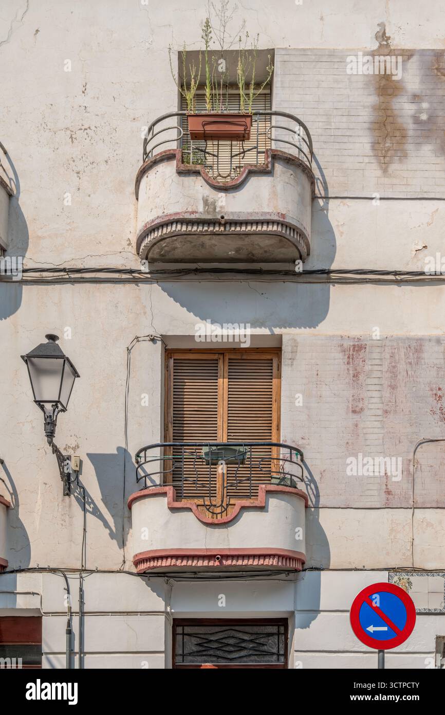 Balcons de style Art déco sur la façade du bâtiment vintage, garde-corps en métal courbé, fenêtres à volets, mur blanc altéré, architecture traditionnelle Banque D'Images