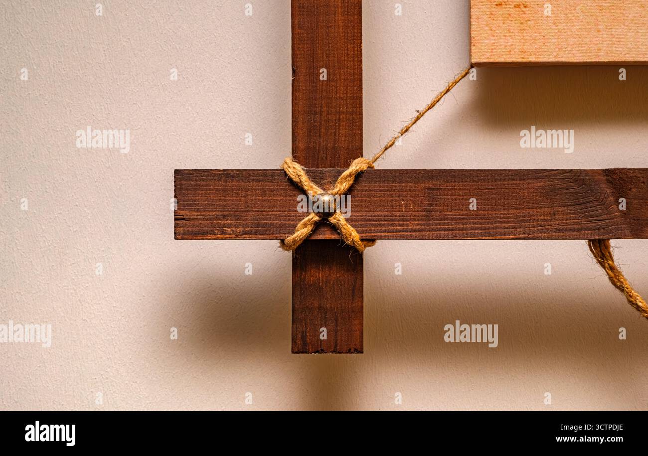 Détail de cadre en bois rustique avec noeud de corde. La texture chaude du bois et le cordon naturel créent un accent confortable. Parfait pour la décoration murale, design d'intérieur. Banque D'Images