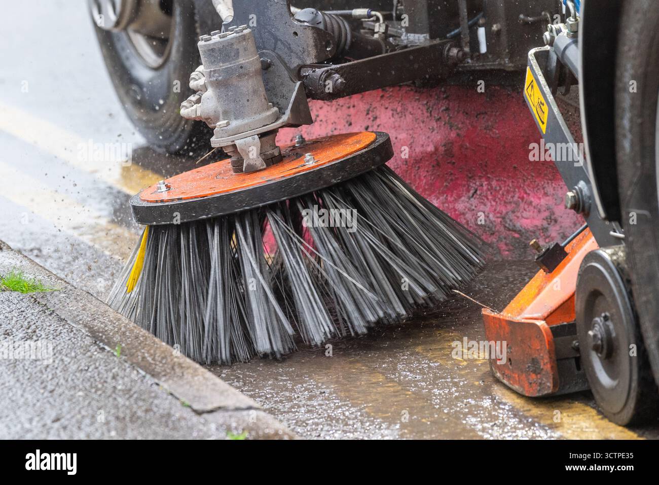 La balayeuse routière du Cork County Council nettoie les gouttières des feuilles près des drains pluviaux à Bantry, West Cork, Irlande. Banque D'Images