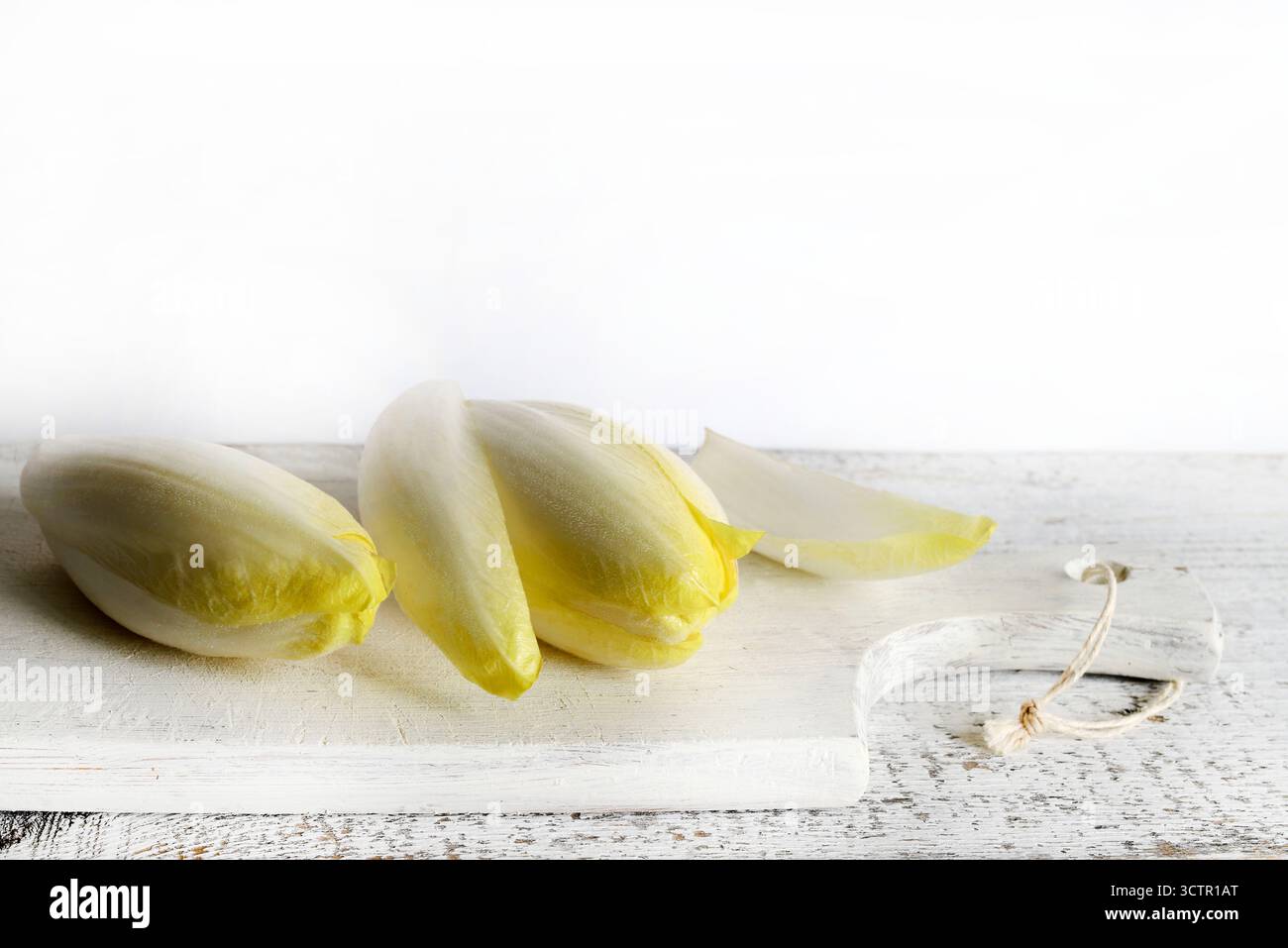 Endives belges crues fraîches (chicorée) isolées sur fond de bois. Nourriture saine et végétarienne. Directement au-dessus. Banque D'Images