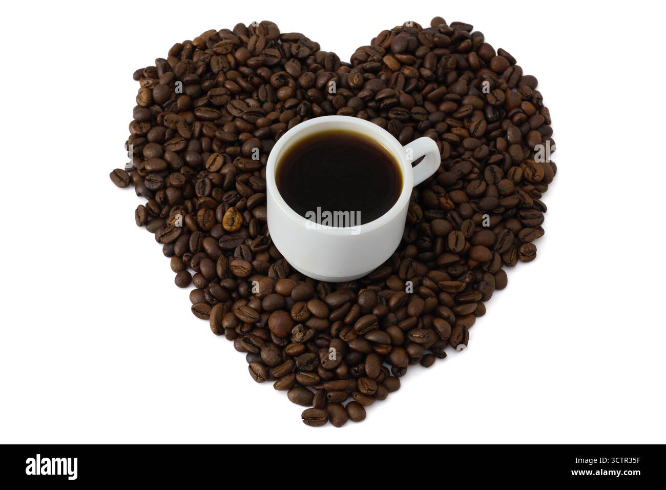 Tasse à café expresso entourée de grains de café torréfiés en forme de coeur Banque D'Images