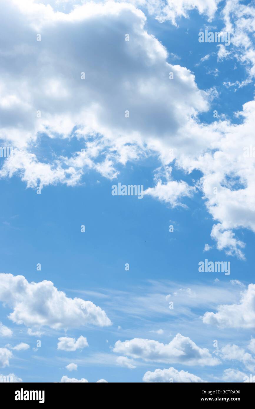Ciel bleu avec des nuages blancs éparpillés par une journée lumineuse symbolisant la liberté et la tranquillité Banque D'Images
