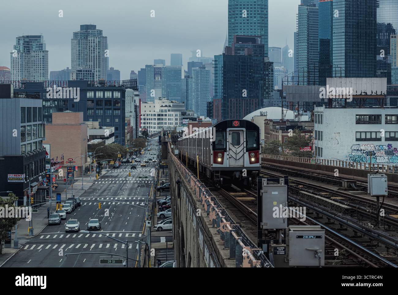 Train urbain de métro sur des voies surélevées avec City Skyline dans Foggy Morning Light - New York City Transportation Scene Banque D'Images