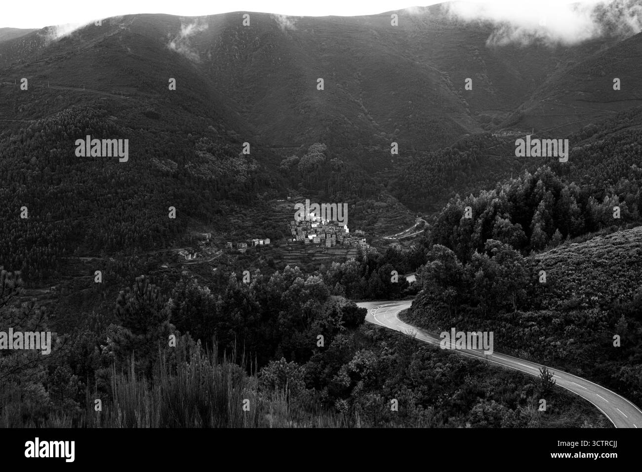 Village de montagne caché au Portugal entouré de collines brumeuses et route sinueuse - paysage noir et blanc spectaculaire Banque D'Images