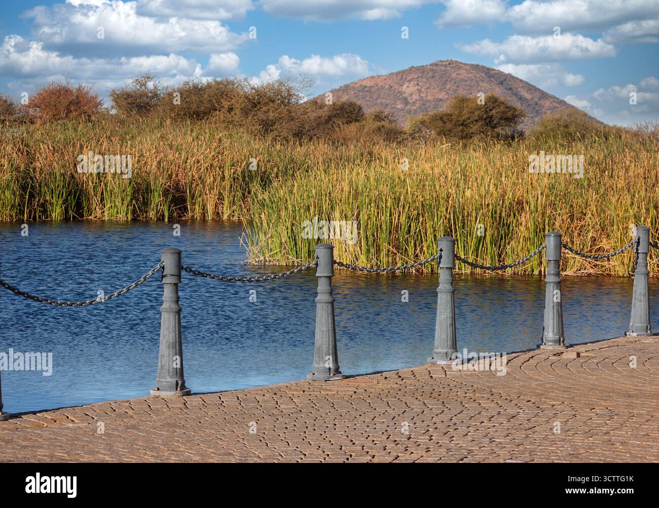 Bâtons de promenade avec chaîne et zone pavée à l'avant, rive du lac avec roseaux et chaîne de montagnes à l'arrière, paysages africains, Banque D'Images