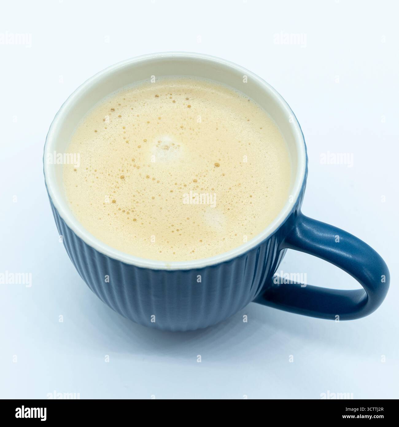 Une tasse de café mousseux dans une tasse bleue sur fond blanc. bonne image pour un menu caffee. Banque D'Images