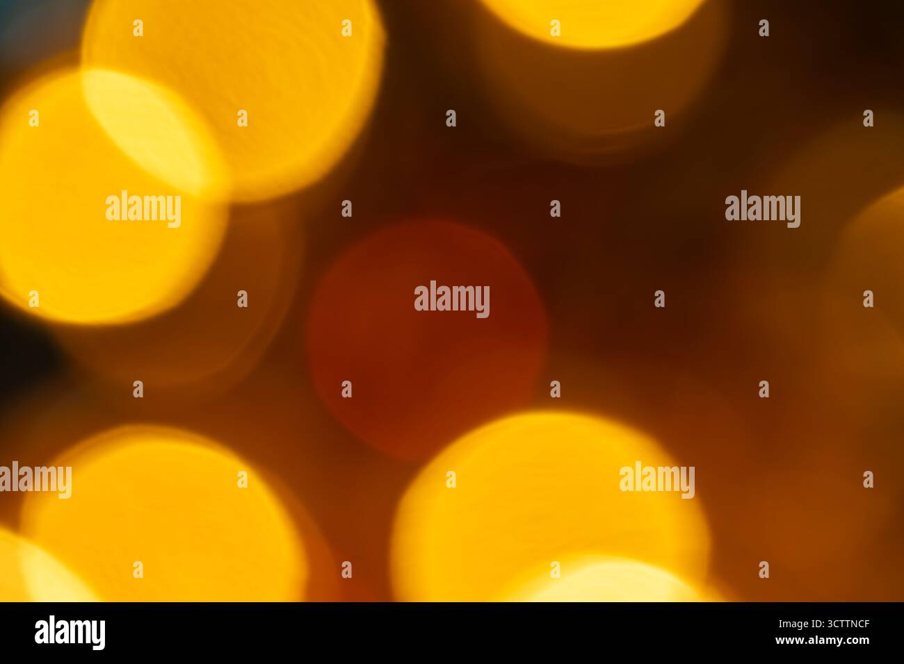 Bokeh orange flou sur fond noir — orbes brillants chauds et reflets dorés doux ; fond flou abstrait adapté au papier peint et au stock Banque D'Images