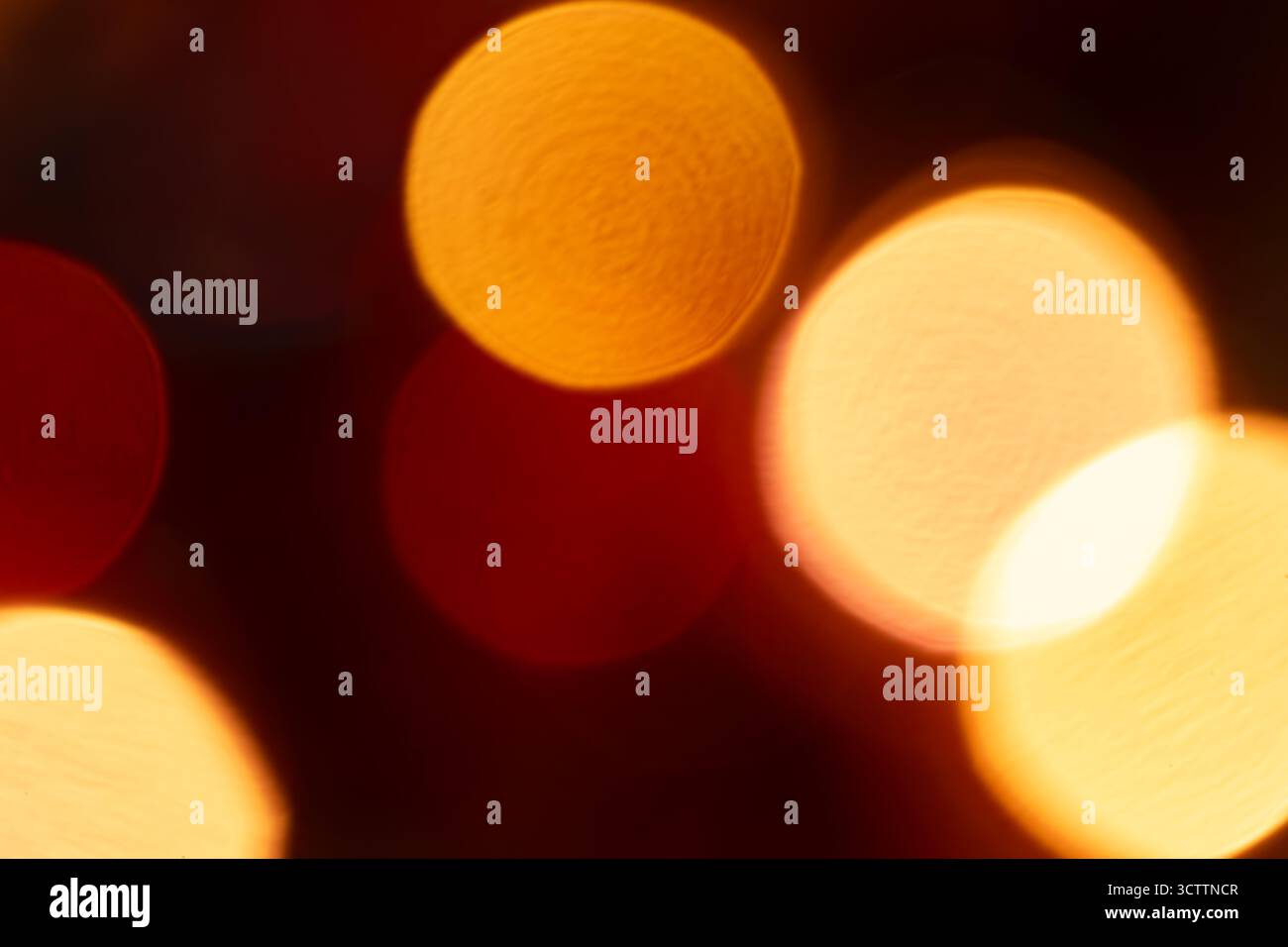 Bokeh orange flou sur fond noir — orbes brillants chauds et reflets dorés doux ; fond flou abstrait adapté au papier peint et au stock Banque D'Images