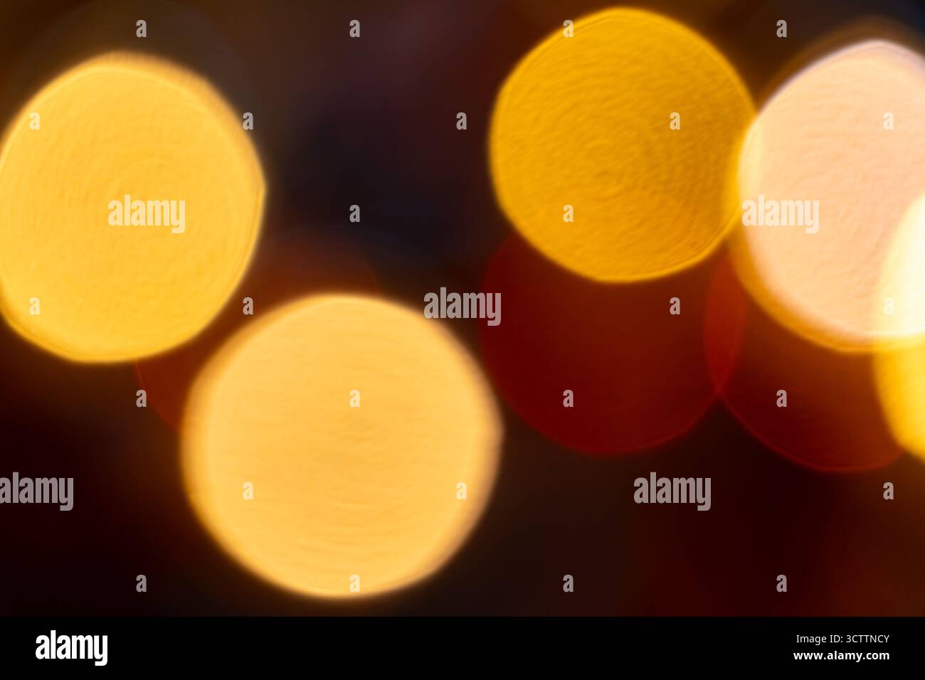 Bokeh orange flou sur fond noir — orbes brillants chauds et reflets dorés doux ; fond flou abstrait adapté au papier peint et au stock Banque D'Images