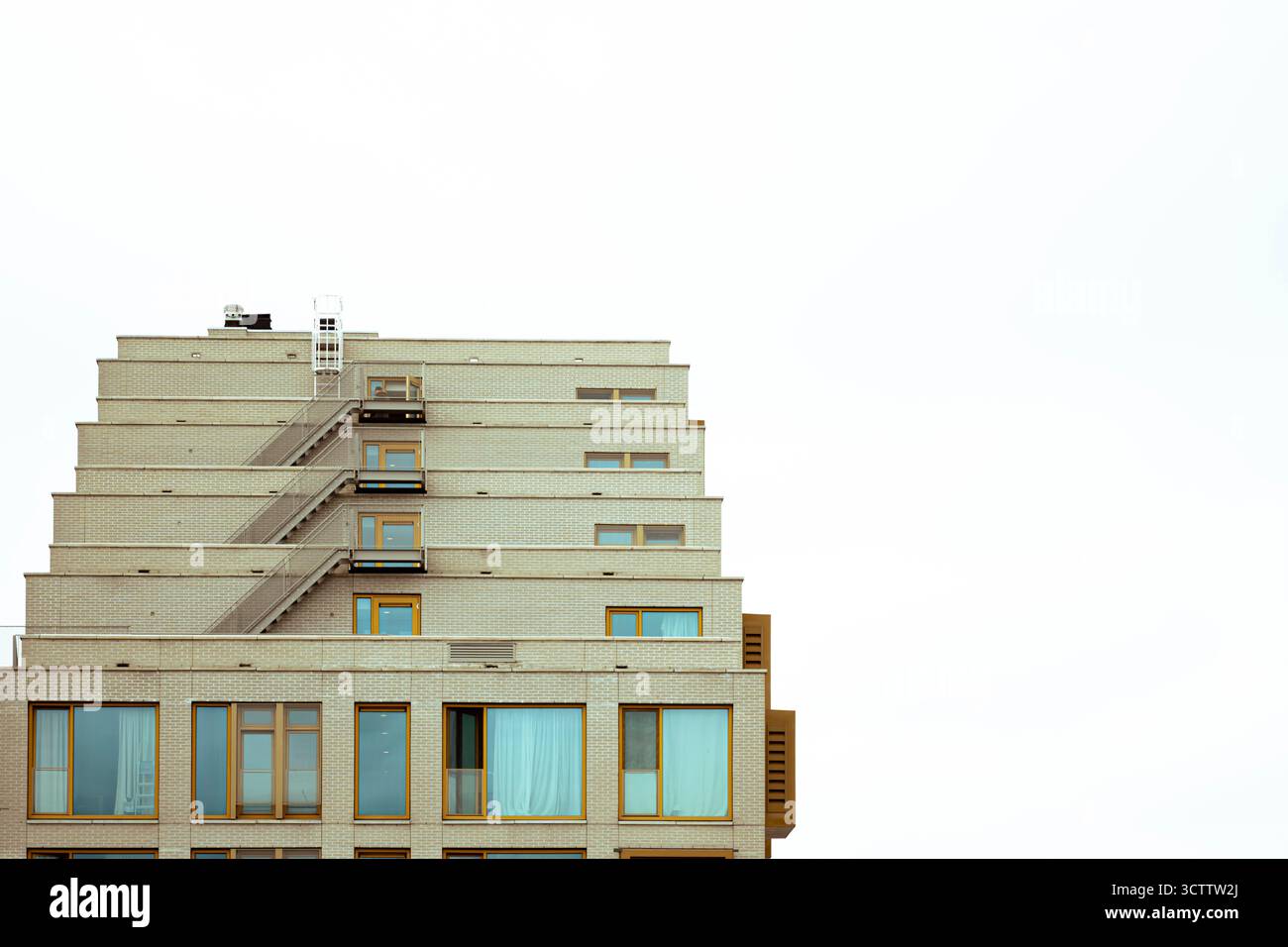 Bâtiment moderne de grande hauteur avec de grands balcons contre un ciel nuageux gris Banque D'Images