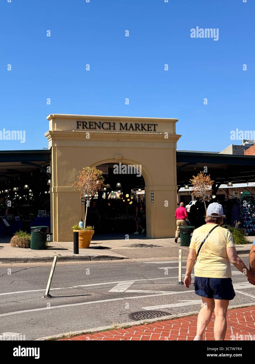 Entrée au marché français historique de la Nouvelle-Orléans, Louisiane, États-Unis, avec un panneau d'arche et des piétons marchant le long du trottoir sur un ensoleillé Banque D'Images