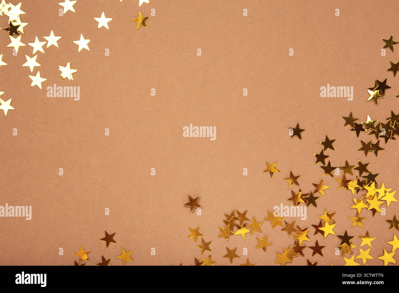 Étoiles de paillettes dorées sur fond marron. Vue de dessus Banque D'Images