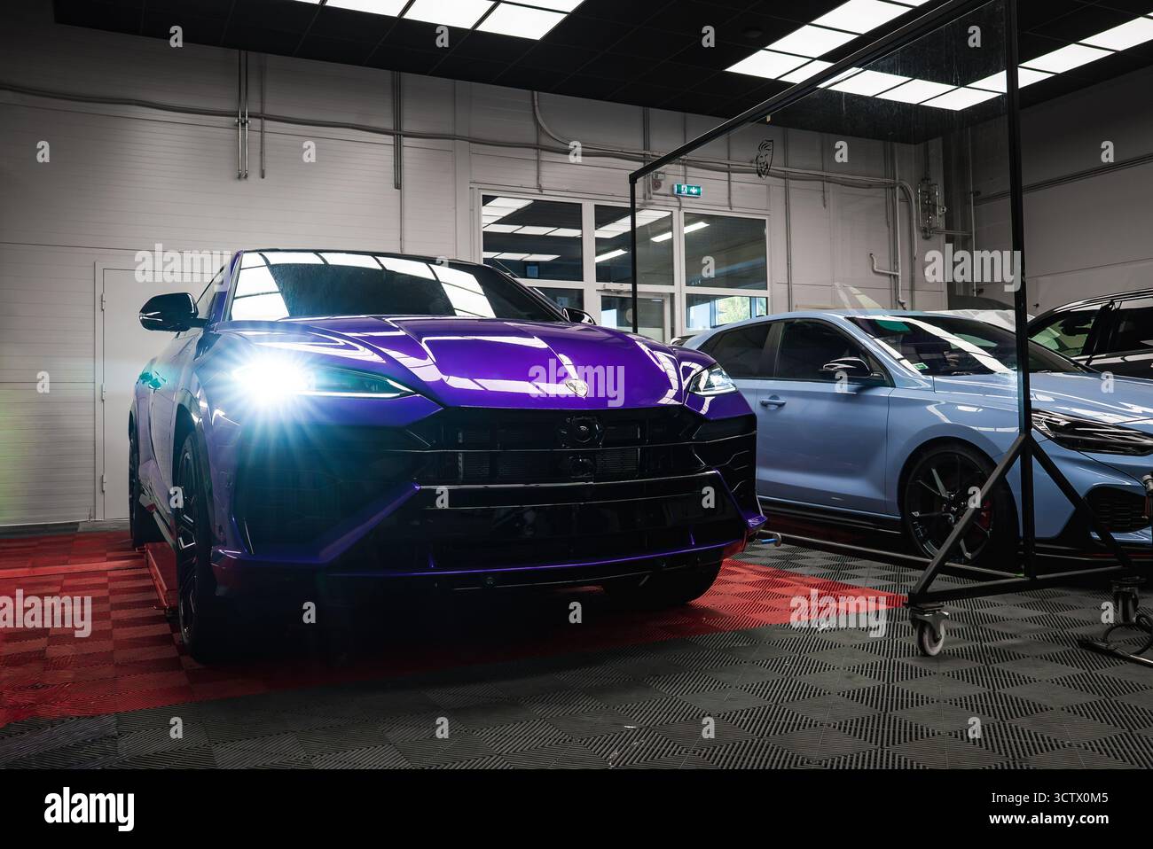 Purple Lamborghini Urus garé à l'intérieur sur plancher damier Banque D'Images