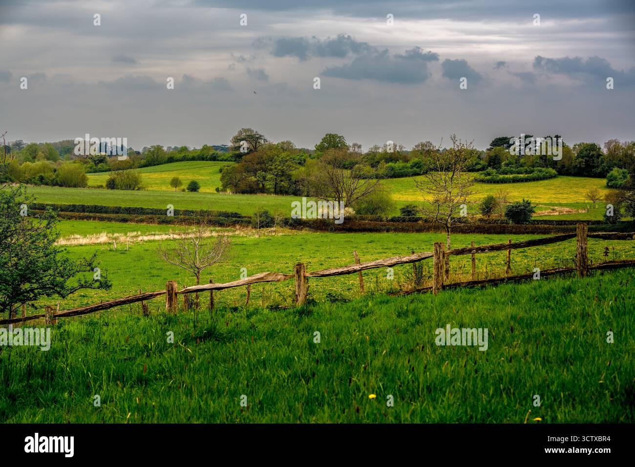 Paysage paisible de campagne anglaise avec Rolling Green Hills et clôture en bois rustique sous ciel nuageux Banque D'Images
