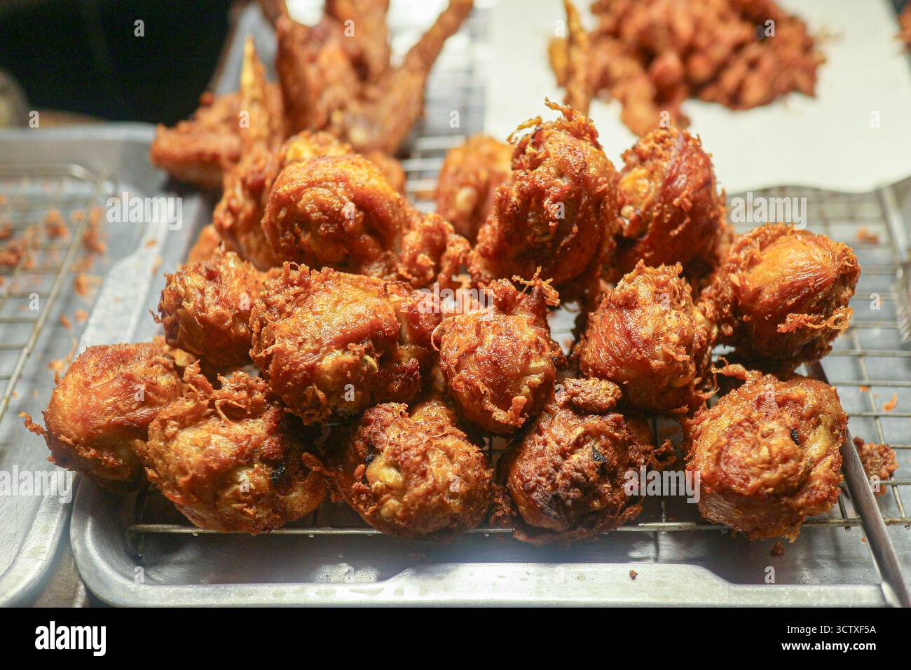Gros plan d'une pile de pilons de poulet frit Hat Yai (Kai Tod Hat Yai). Une collation culinaire populaire du sud de la Thaïlande avec un revêtement croustillant. Banque D'Images