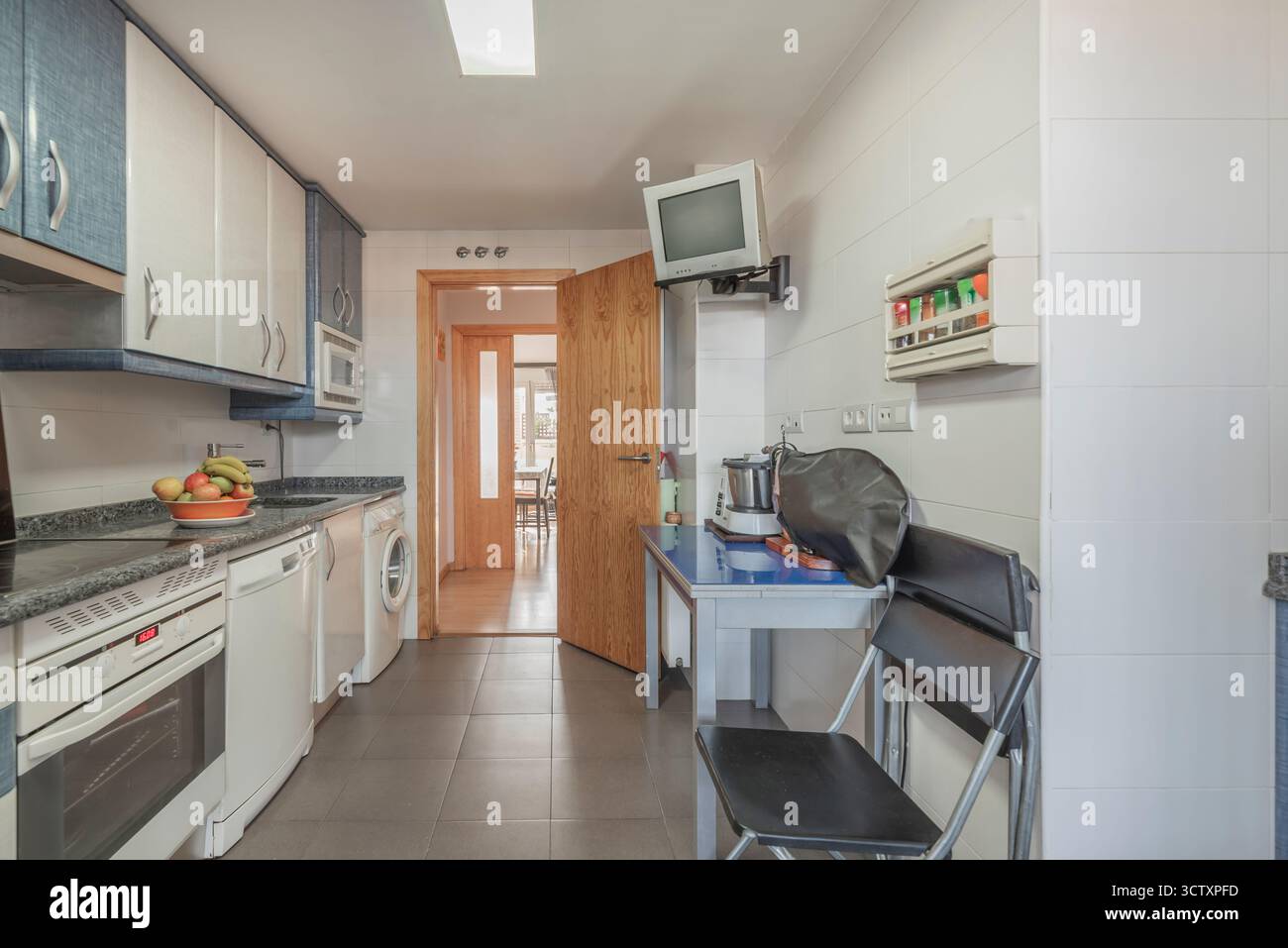 Cuisine contemporaine avec un mur de carrelage hexagonal, armoires modulaires et appareils électroménagers Banque D'Images