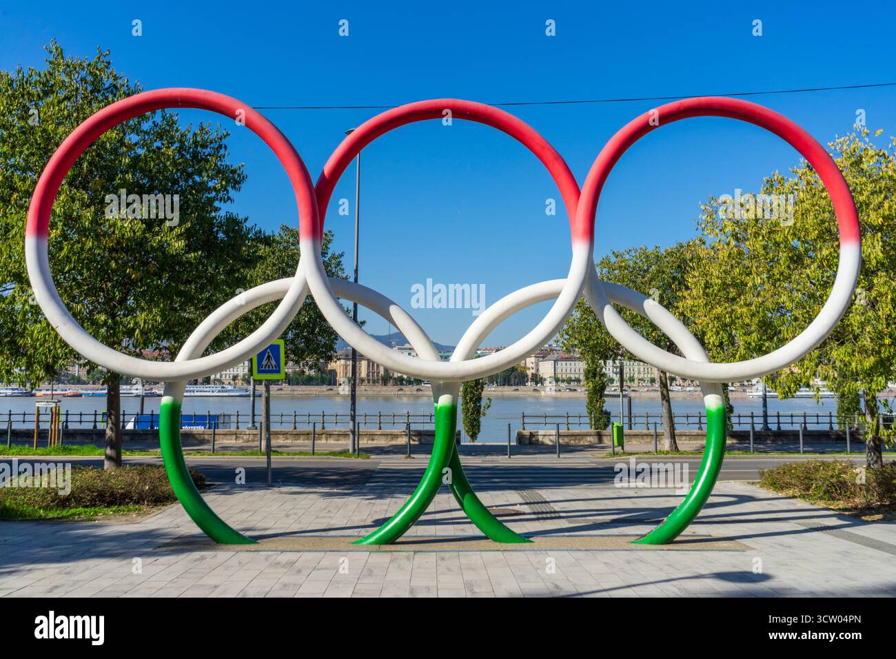 Anneaux olympiques peints en rouge, blanc et vert dans le parc Olimpia de Budapest, symbolisant les aspirations olympiques de la Hongrie. Banque D'Images