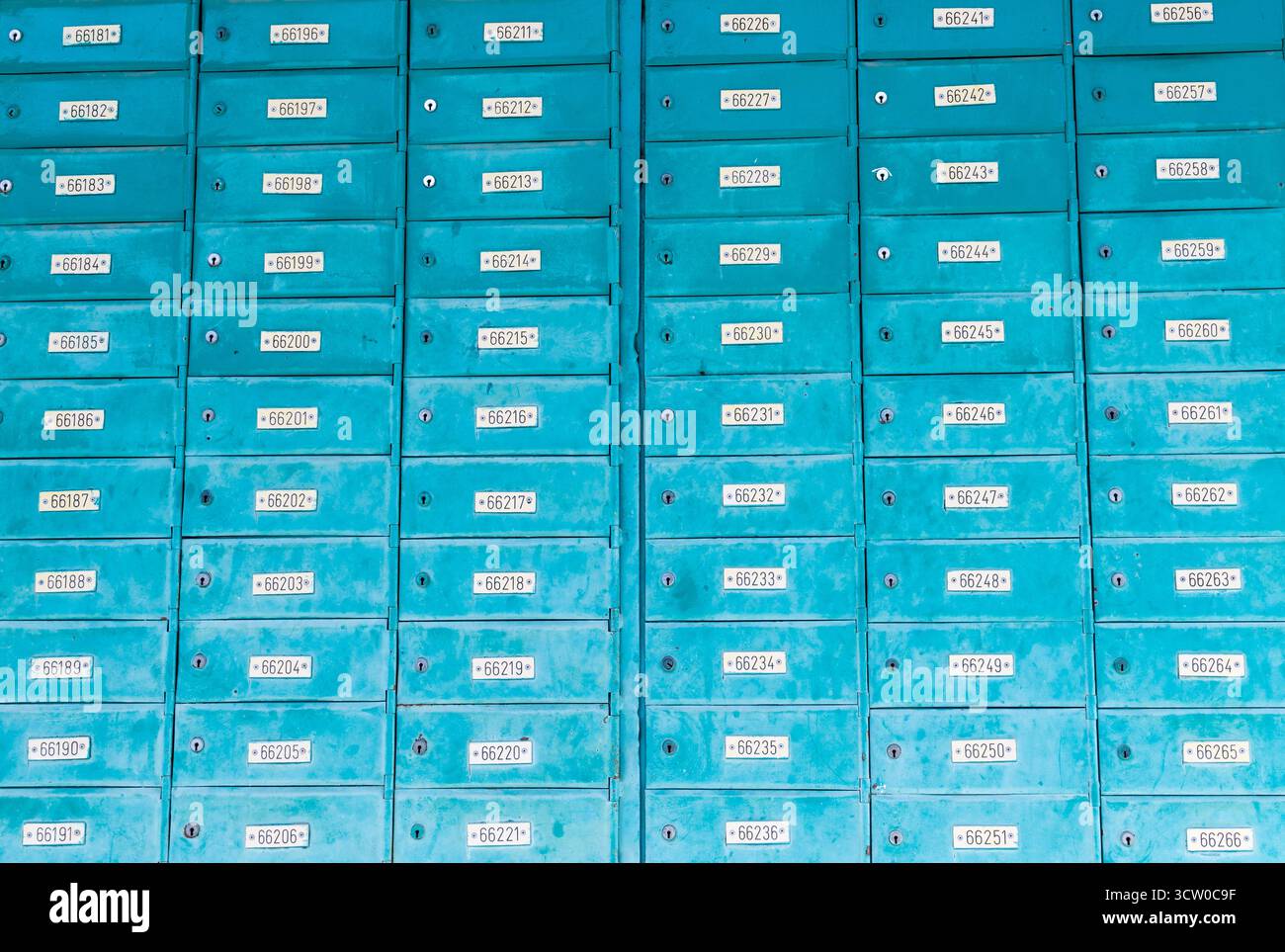 Un mur bleu éclatant de boîtes aux lettres bien agencées présentant d'excellentes solutions de stockage postal pour tous Banque D'Images