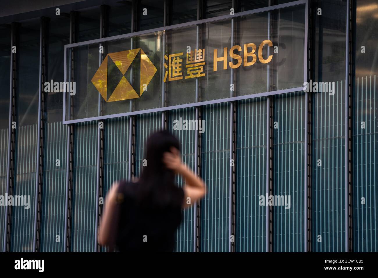 Hong Kong, Hong Kong. 9 octobre 2025. Une femme debout devant un logo HSBC au siège de HSBC le 9 octobre 2025 à Hong Kong. HSBC (Hongkong et Shanghai Banking Corporation) lancera une offre pour prendre Hang Seng Bank Private. (Crédit image : © Vernon Yuen/Nexpher images via ZUMA Press Wire) USAGE ÉDITORIAL SEULEMENT ! Non destiné à UN USAGE commercial ! Banque D'Images