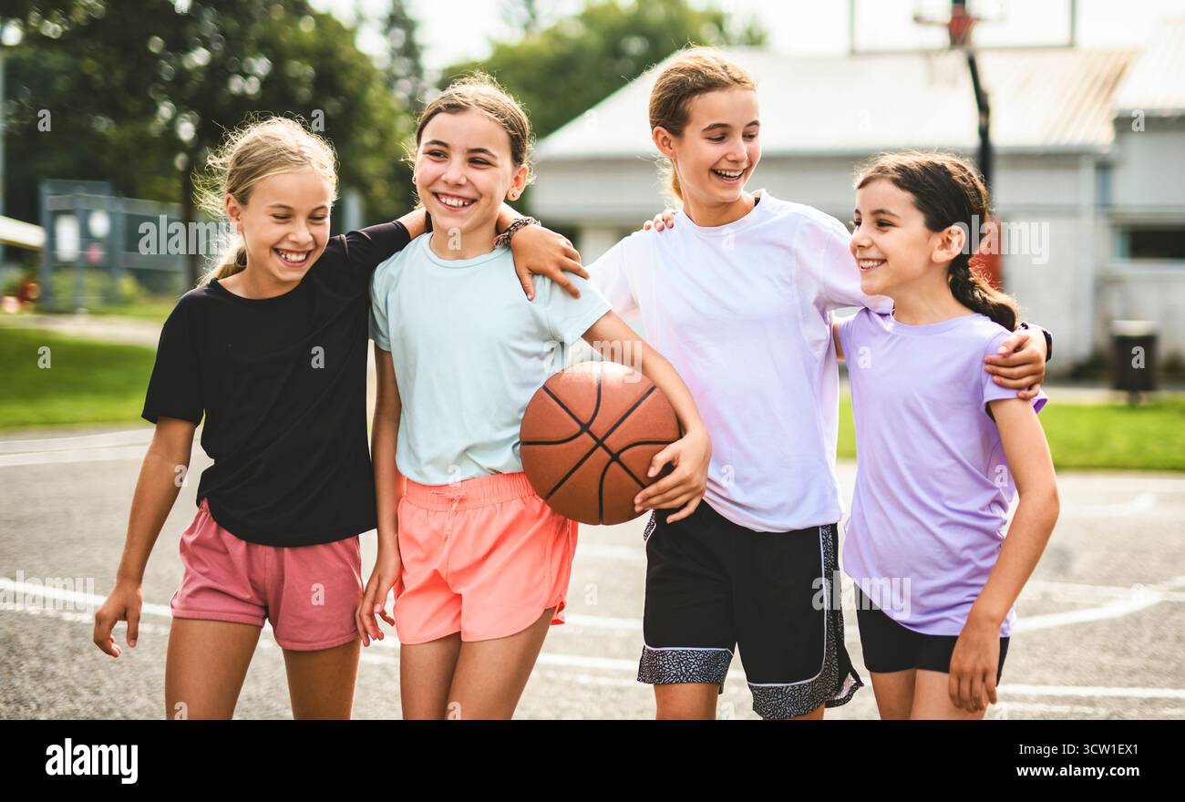 L'équipe des filles des enfants dans les vêtements de sport jouant un jeu de basket-ball Banque D'Images