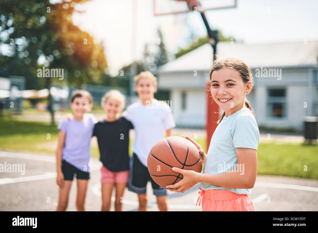 L'équipe des filles des enfants dans les vêtements de sport jouant un jeu de basket-ball Banque D'Images