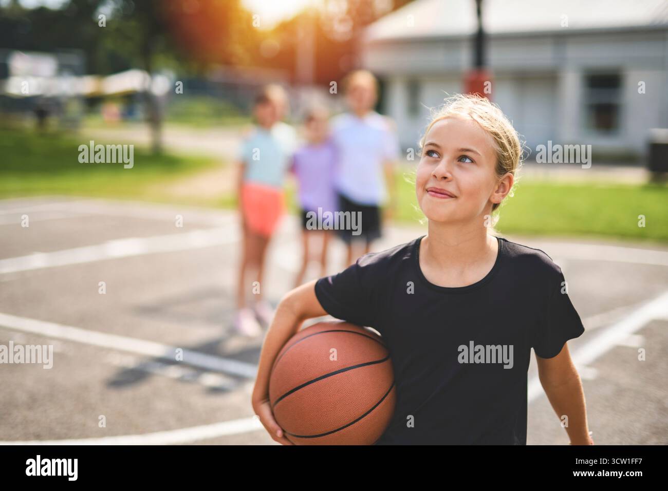 L'équipe des filles des enfants dans les vêtements de sport jouant un jeu de basket-ball Banque D'Images