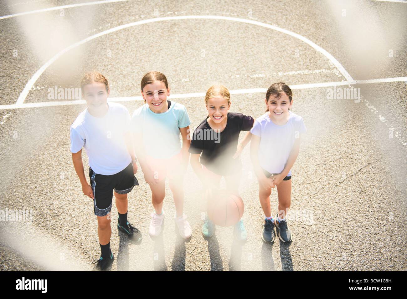 L'équipe des filles des enfants dans les vêtements de sport jouant un jeu de basket-ball Banque D'Images