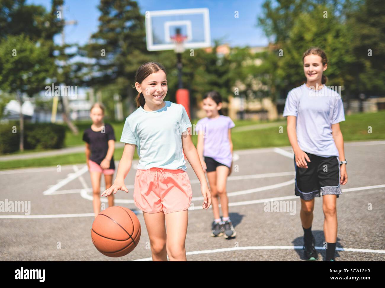 L'équipe des filles des enfants dans les vêtements de sport jouant un jeu de basket-ball Banque D'Images