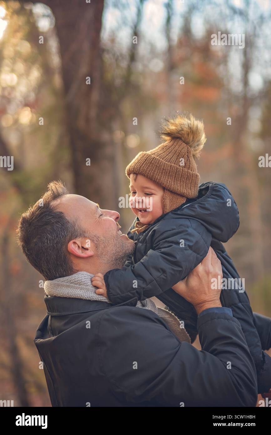 Un papa joyeux et son petit bébé. papa et enfant s'amusent, rient et profitent de la nature en plein air au parc d'automne. Banque D'Images