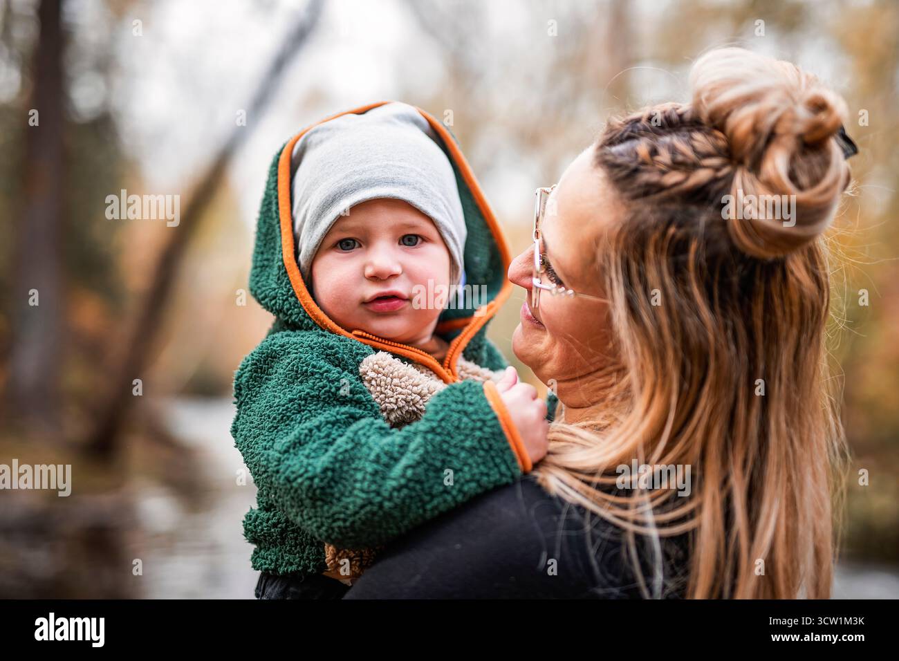 Une maman joyeuse et son petit bébé. mère et enfant s'amusent, rient et profitent de la nature en plein air au parc d'automne. Banque D'Images