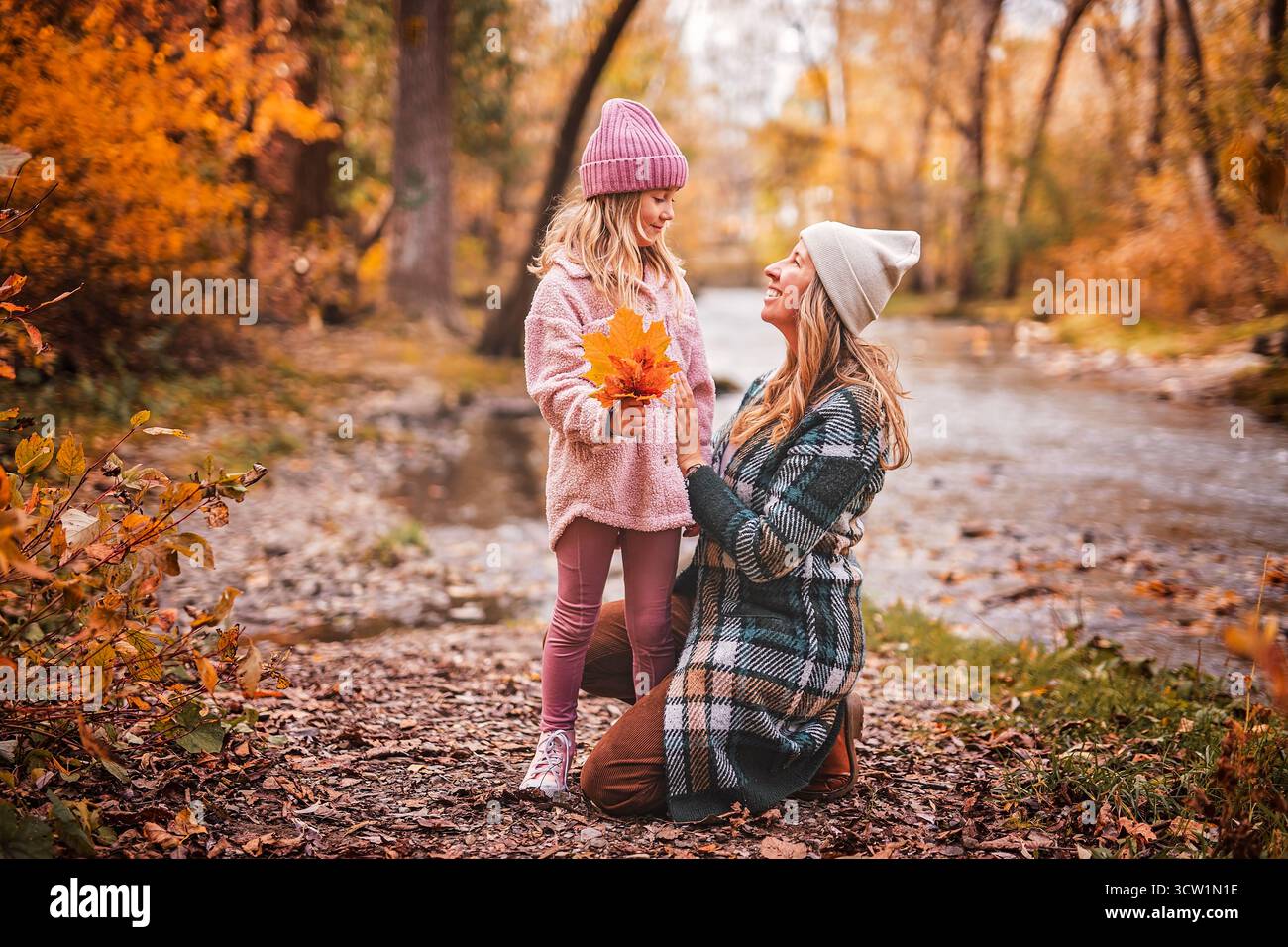 Une maman joyeuse et sa petite fille. mère et enfant s'amusent à l'extérieur au parc d'automne. Banque D'Images