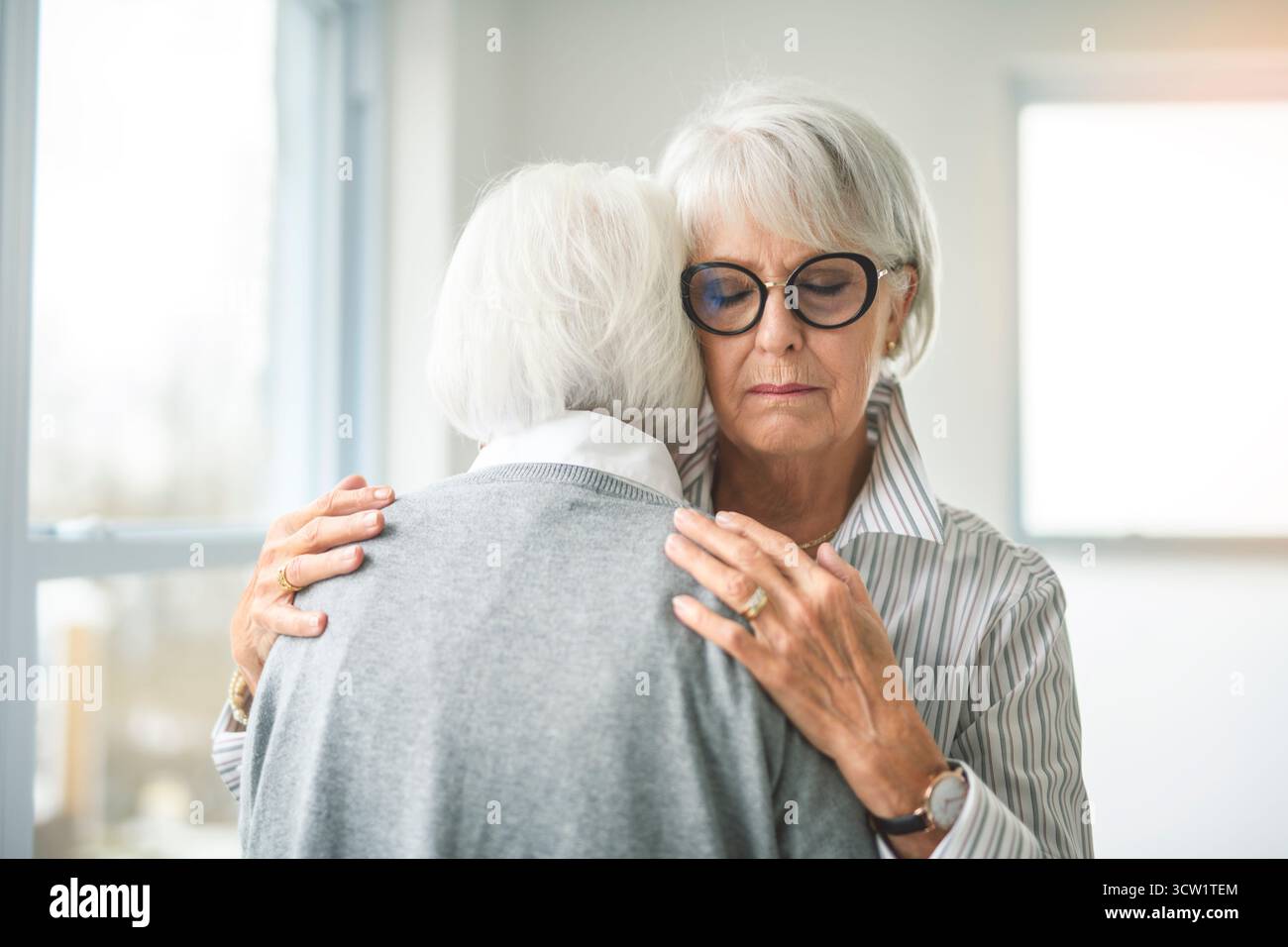 Un portrait de deux femmes âgées sur fond gris câlin ensemble Banque D'Images