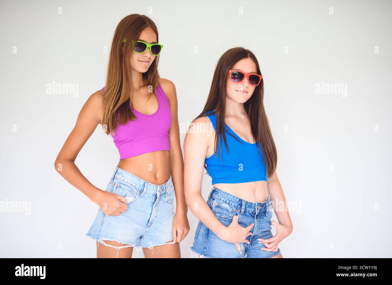 Un portrait de deux adolescentes de 14 ans près d'un mur coloré avec chemise de couleur Banque D'Images