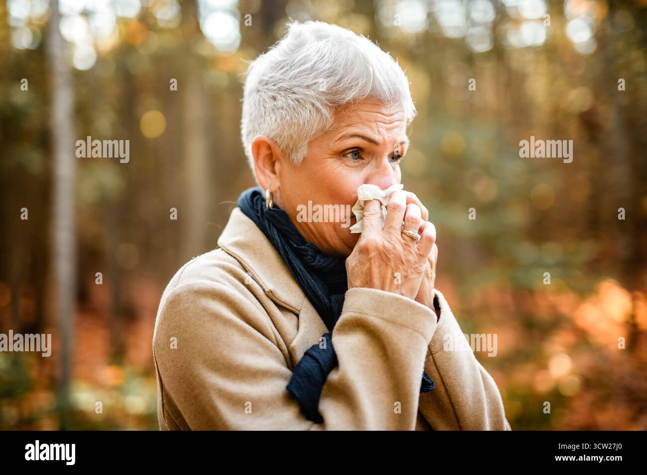 Une femme toussant et se soufflant le nez en automne. Rhume et grippe Banque D'Images