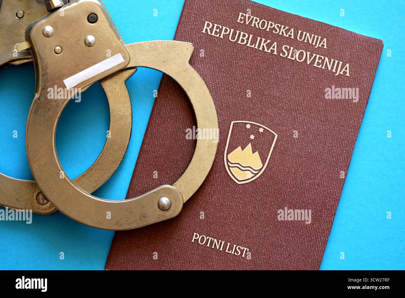 Passeport slovène avec menottes de police sur la table de près. Niveau de criminalité et arrestations en Europe concept Banque D'Images