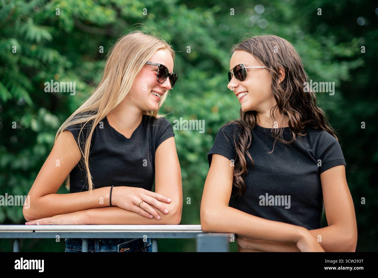 Une jeune copine debout dans la rue de la ville. Portrait extérieur de la joyeuse belle adolescente sur fond urbain. Banque D'Images