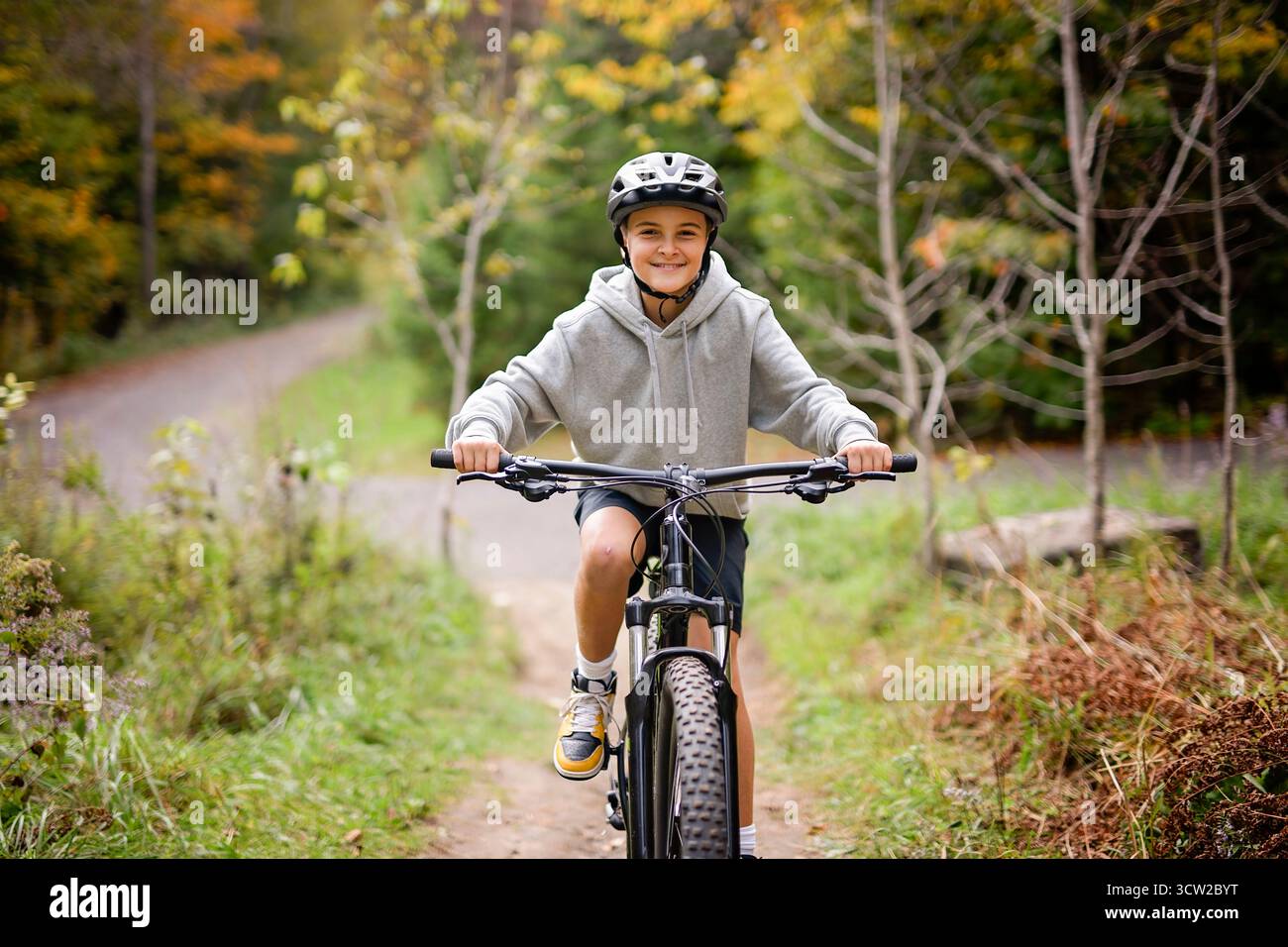 Garçon dans un casque à vélo. Garçon dans un casque de sécurité à vélo dans le parc de la ville. Enfant premier vélo. Activités de plein air pour les enfants en été. Enfant à vélo. Petit c Banque D'Images
