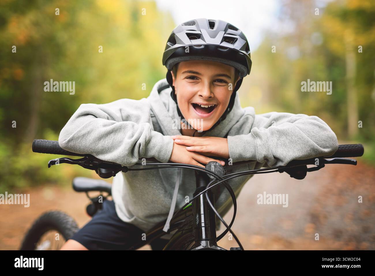 Garçon dans un casque à vélo. Garçon dans un casque de sécurité à vélo dans le parc de la ville. Enfant premier vélo. Activités de plein air pour les enfants en été. Enfant à vélo. Petit c Banque D'Images