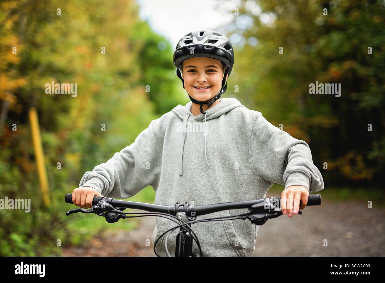 Garçon dans un casque à vélo. Garçon dans un casque de sécurité à vélo dans le parc de la ville. Enfant premier vélo. Activités de plein air pour les enfants en été. Enfant à vélo. Petit c Banque D'Images