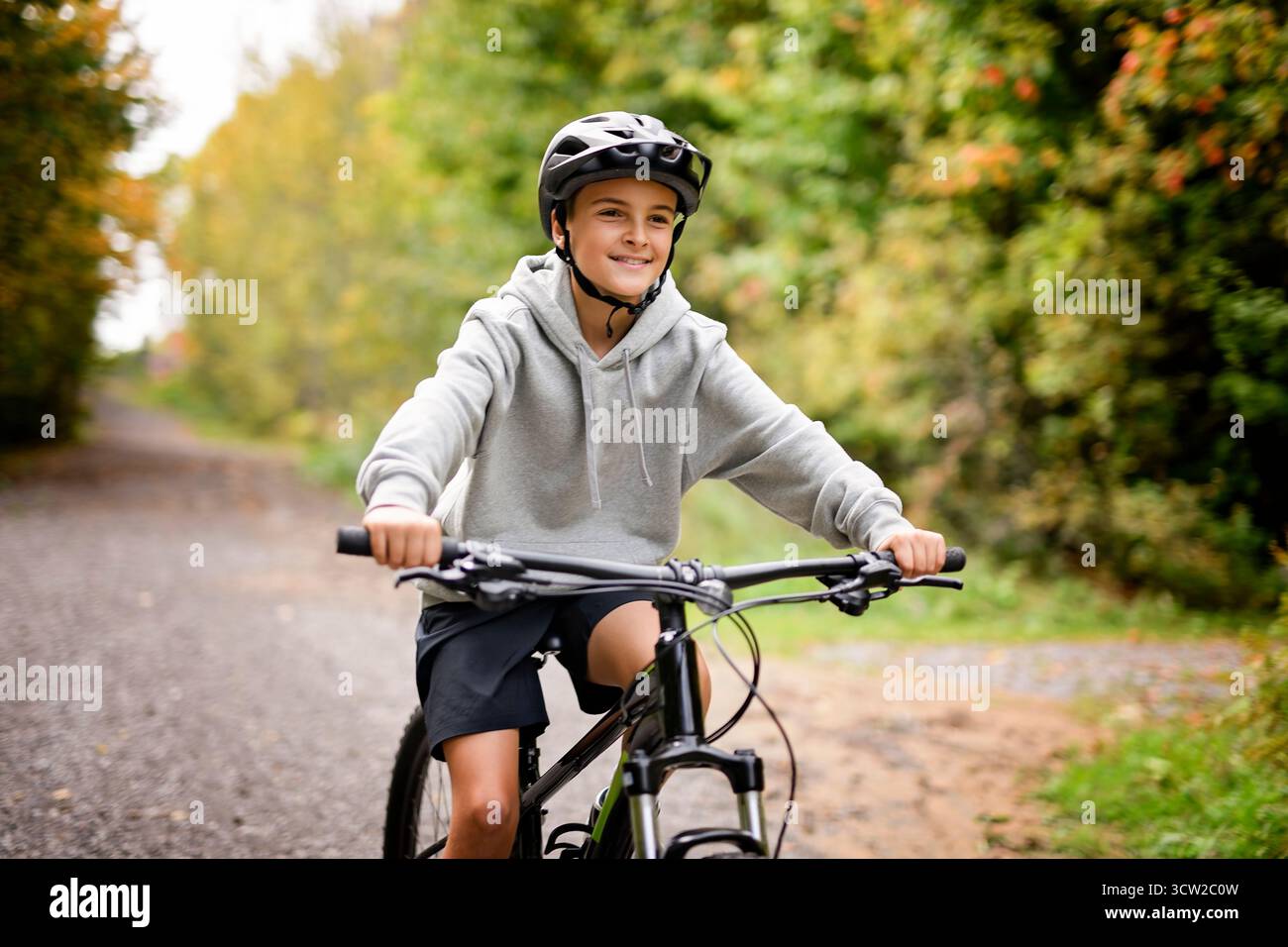 Garçon dans un casque à vélo. Garçon dans un casque de sécurité à vélo dans le parc de la ville. Enfant premier vélo. Activités de plein air pour les enfants en été. Enfant à vélo. Petit c Banque D'Images