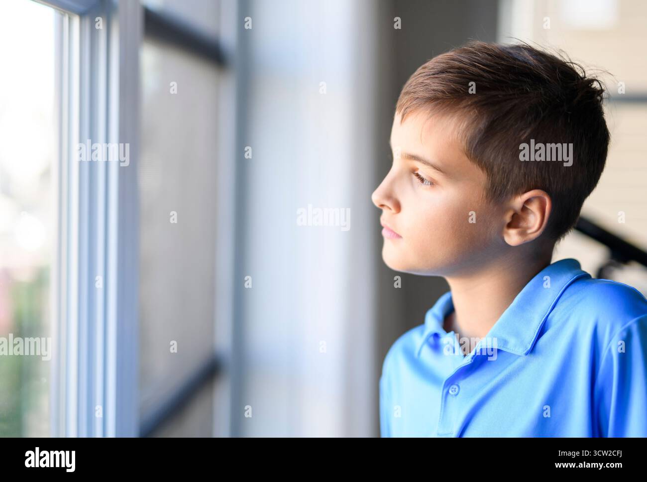 Un jeune adolescent avec près de la fenêtre à la maison Banque D'Images