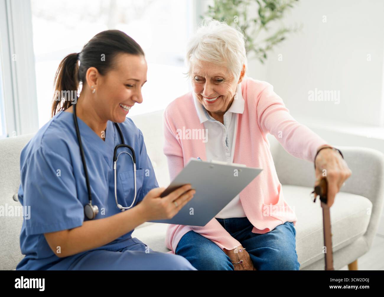 Portrait d'une jeune infirmière médecin avec une patiente âgée à domicile lors d'une consultation Banque D'Images