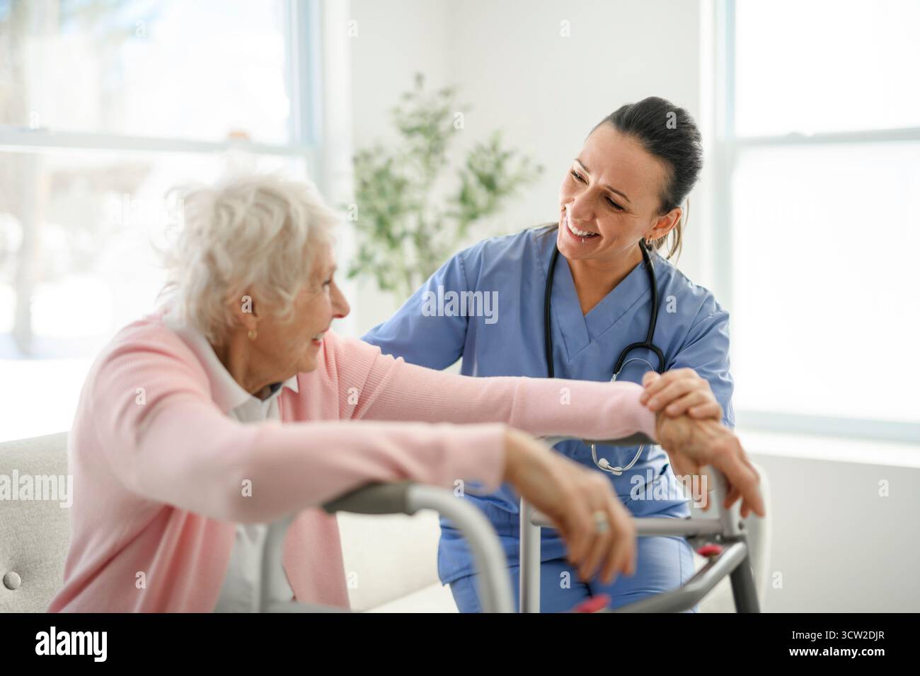 Portrait d'une jeune infirmière médecin avec une patiente âgée à domicile lors d'une consultation Banque D'Images